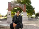 A young woman smiles on campus